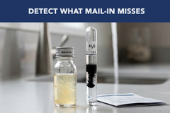 A Waterlogix Premium Water Test kit by US Water Systems Inc sits on a counter with test tubes and pamphlet; text above reads, Detect What Mail-In Misses with our well water test.