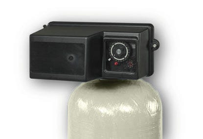 The US Water Backwashing GAC Carbon Filter 2 Inch (28-64GPM) by US Water Systems Inc features a black control valve with dial atop a beige cylindrical tank, ideal for activated carbon water treatment or filtration.