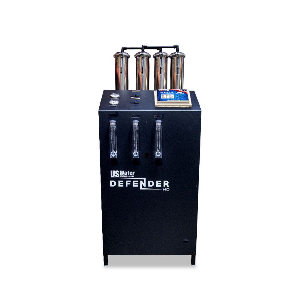 The Defender Commercial RO System by US Water Systems Inc, featuring gauges, labels, four vertical cylinders, and a control panel on top, provides an eco-friendly solution for your water filtration needs.